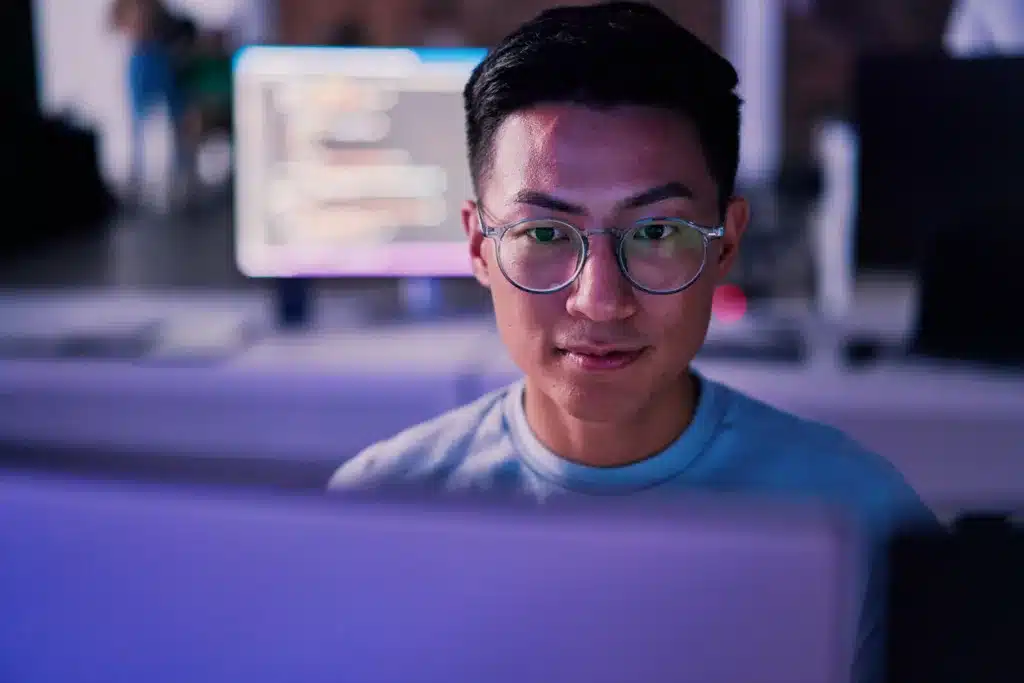 Businessman, computer or programming code in night office for software development, cybersecurity or database safety. Asian programmer, developer or engineer on technology for web 3.0 coding in dark