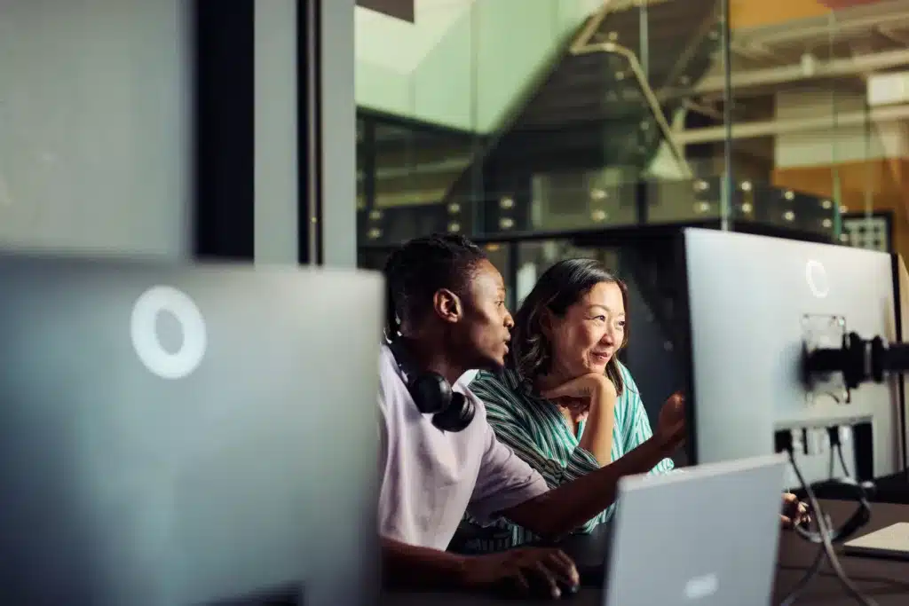 Programmers working together on a computer in office discussing a project