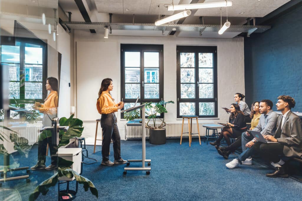 A woman delivers a business presentation to an audience of engaged listeners